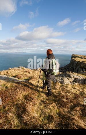 Eine Hügel-Walker blickt auf das Meer vom Klippe Weg zu Fair Head, Ballycastle, County Antrim, Nordirland. Stockfoto