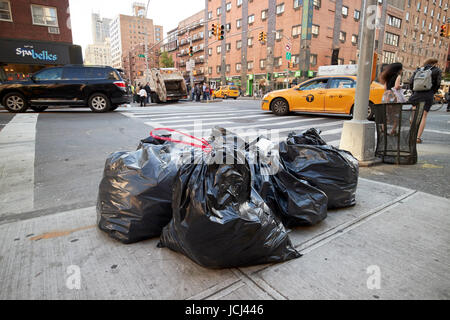 Müll auf Bürgersteig in schwarzen Plastiktüten für Kollektion New York Straßen USA links Stockfoto