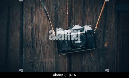 Alte graue Zenit in eine braune Ledertasche an einer Holzwand Hintergrund hängen. Stockfoto