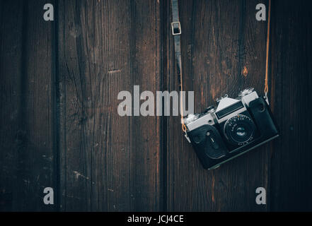 Alte graue Zenit in eine braune Ledertasche an einer Holzwand Hintergrund hängen. Stockfoto