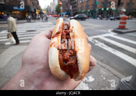 Mann mit Chili Hot Dog Essen in New York City, USA Stockfoto