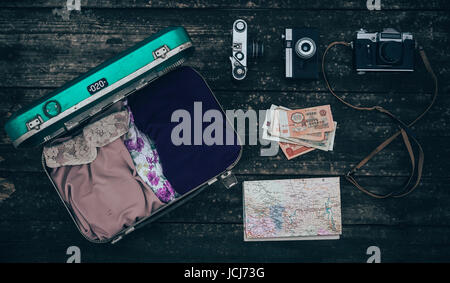 Vintage Hipster Koffer packen vor Reiseantritt mit alten Koffer, Kamera und Zubehör auf einem Holztisch, Ansicht von oben Stockfoto