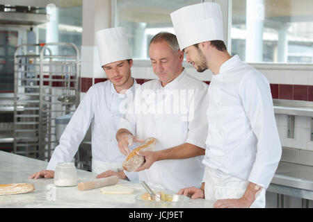 Lehrlinge in der Bäckerei lernen von erfahrenen professionellen Stockfoto