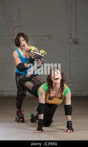 Bully Roller Derby Skater verdrehen das Bein einer Frau Stockfoto