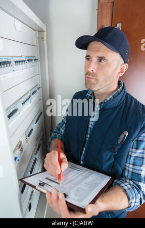 Techniker, die moderne computergesteuerte Maschine Einstelldaten aufschreiben Stockfoto