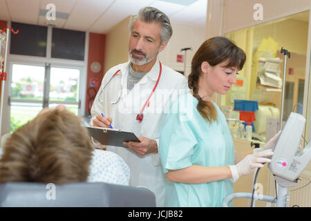 Arzt und Krankenschwester mit Tablet pc Computer besuchen ältere Patienten Stockfoto