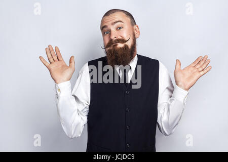 Ich weiß nicht. Gut aussehend Geschäftsmann mit Bart und Schnurrbart schaut in die Kamera und verwirrt. Studio gedreht, auf grauem Hintergrund. Stockfoto