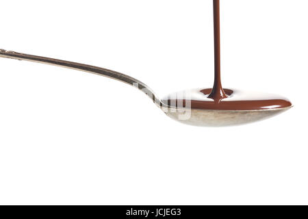 Schokolade in einem Löffel gegossen auf weißem Hintergrund Stockfoto