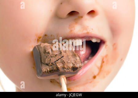 das Kind essen Schokolade Lutscher Stockfoto