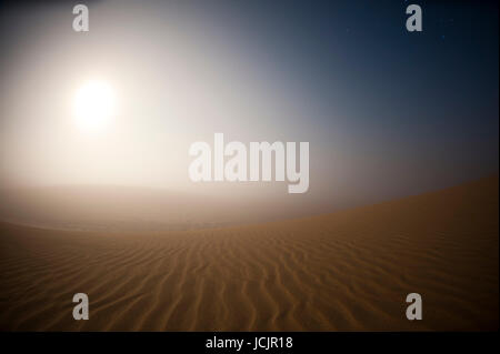 Mondaufgang im Nebel über Sanddünen, Skeleton Coast Nationalpark, Namibia. Stockfoto