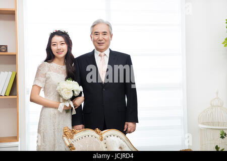 Lächelnde Braut und ihr Vater Arm in arm Stockfoto