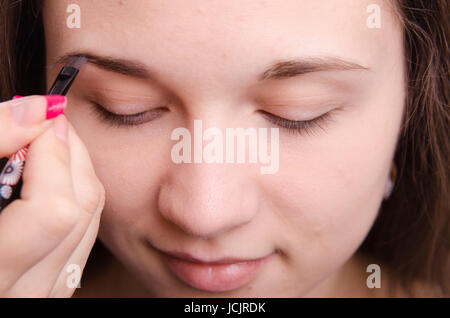 Make-up-Künstler malt der Augenbrauen eines schönen jungen Mädchens in der Verfassung Stockfoto