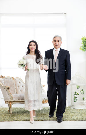 Lächeln, Braut und ihr Vater stehen Arm in arm Stockfoto