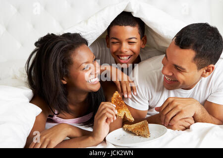 Familie genießen das Frühstück im Bett Stockfoto