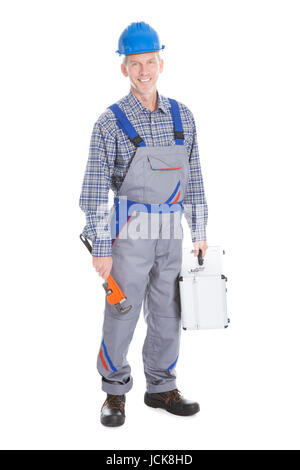 Glückliche junge Arbeiter halten Toolbox und Schraubenschlüssel auf weißem Hintergrund Stockfoto