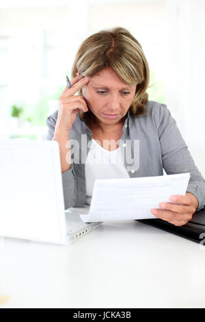 Ältere Frau, die Probleme mit dem Verständnis von offizieller Dokumenten Stockfoto