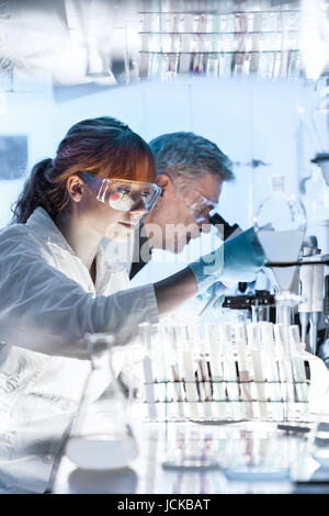 Gesundheitswesen Forscher arbeiten im Life-Science-Labor. Junge weibliche Forschung Wissenschaftler und Senior männlichen Vorgesetzten Vorbereitung und Analyse von microsc Stockfoto