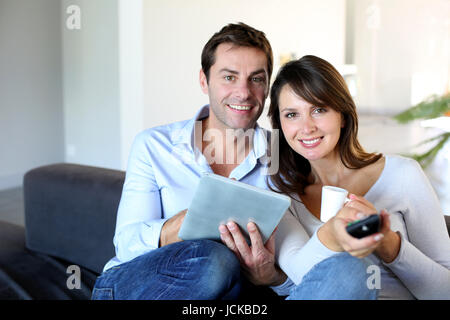 Paar sitzt im Sofa Auswahl TV-Programm Stockfoto