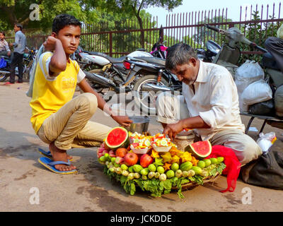 Mann mit einem jungen mit Obst außerhalb Jama Masjid in Fatehpur Sikri, Uttar Pradesh, Indien. Die Stadt wurde im Jahre 1569 vom Mogulkaiser Akb gegründet. Stockfoto