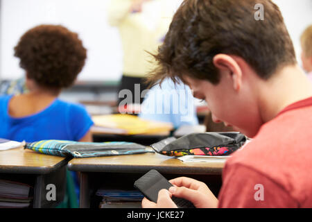 SMS auf dem Handy In der Klasse Schüler Stockfoto