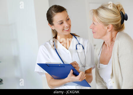 Krankenschwester, die ältere Frau Presciption verleihen Stockfoto