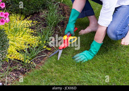 Bäckerlehrling Mit Handschuhen Und Einer Gartenschere Bei der Gartenarbeit Im Sommer Im Freien Stockfoto