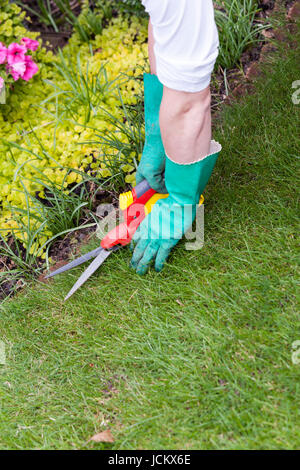 Bäckerlehrling Mit Handschuhen Und Einer Gartenschere Bei der Gartenarbeit Im Sommer Im Freien Stockfoto