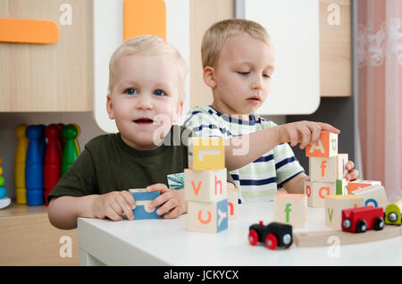 Kinder Jungen spielen mit Spielzeug Blöcke zu Hause oder im Kindergarten. Kinder Kindergarten Vorschule Kindergarten Schulkind bunte Konzept spielen Stockfoto