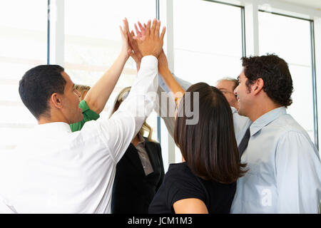 Business-Team geben einander hoch fünf Stockfoto
