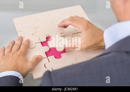 Geschäftsmann Montage Jigsaw Puzzle. Über die Schulter-Blick Stockfoto