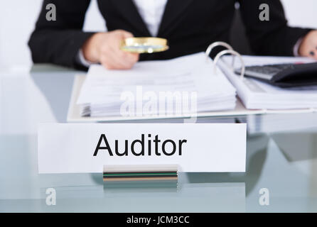 Nahaufnahme der Uditor Prüfung Finanzdokumente am Schreibtisch im Büro Stockfoto