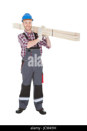 In voller Länge Portrait von junge Arbeiter tragen Holzplanken auf weißem Hintergrund Stockfoto