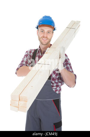 In voller Länge Portrait von junge Arbeiter tragen Holzplanken auf weißem Hintergrund Stockfoto