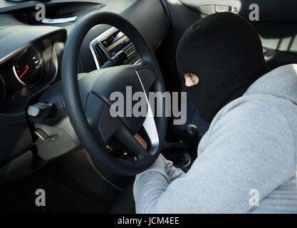 Seitenansicht der Dieb mit Schraubendreher im Auto Stockfoto