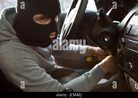 Seitenansicht der Dieb mit Schraubendreher im Auto Stockfoto