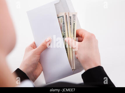 Zugeschnittenes Bild der Unternehmerin, Amerikanische Banknoten im Umschlag im Büro Stockfoto