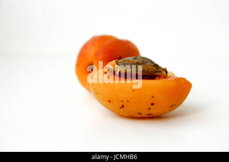 Saftiger Pfirsich getrocknete Aprikosen Orange. Zwei Hälften werden mit einem Knochen geschnitten. auf einem weißen Hintergrund. Foto für Ihr design Stockfoto