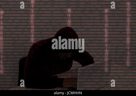 Computer-Hacker tragen ein Kapuzenshirt mit Laptop im Dunkeln. Der Mann bricht den Zugriff auf Daten zu stehlen und infizieren Computer und Systeme. Hackin Stockfoto