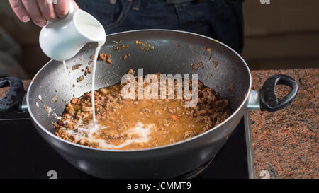 Bolognese Sauce für italienische Pasta kochen: Milch gießen Stockfoto