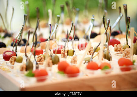 Close-up niedrigen Winkel des Tabletts mit Fingerfood besteht aus frischen Oliven, Walnüsse und Kirschen Stockfoto