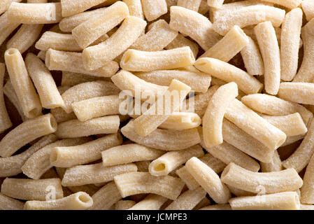 Von oben Nahansicht des rohen handgemachte Maccheroncini Nudeln in Mehl. Essen-Textur Stockfoto