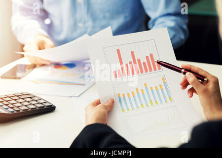 Geschäftsleute, die Erörterung von Grafik und Tabelle im Büro Stockfoto