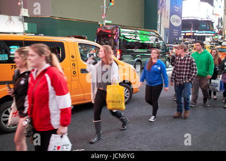 Passanten auf der Straße durch gestoppt Verkehr Abend in Times Square New York City USA bewusste Bewegung verwischen Stockfoto