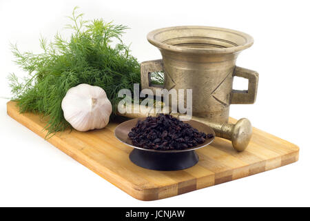 Still Life Gewürze, duftenden Sumach, Ringelblume Staminas in Kupfer Vase auf einem Holzbrett auf einem Hintergrund von einem stern Stupa zum Mahlen von Gewürzen, Trauben o Stockfoto