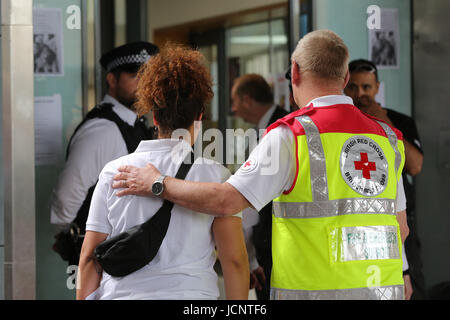 London, UK. 16. Juni 2017. Ein Mitglied des Roten Kreuzes hilft einer Frau. Bildnachweis: Dinendra Haria/Alamy Live-Nachrichten Stockfoto