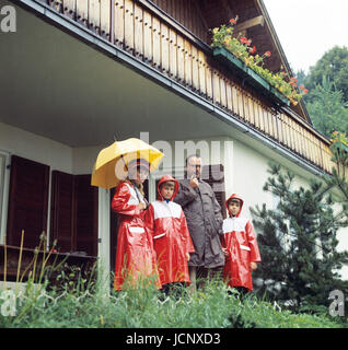 Der Vorsitzende der CDU und Ministerpräsident von Rheinland-Pfalz, Helmut Kohl (2. von rechts), im Juli 1974 mit seiner Frau Hannelore und seinen Söhnen, alle gekleidet mit Regenschutz, im Urlaub in St. Gilgen am Wolfgangsee, Österreich. | weltweite Nutzung Stockfoto