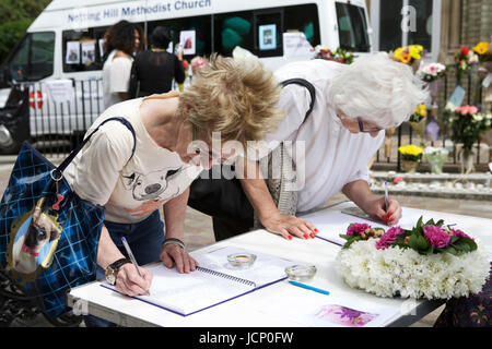 London, Großbritannien. Juni 2017. Das Grenfell Tower Desaster, in West London. Ein 24-stöckiges Wohngebäude, das durch einen Brand zerstört wurde. Anwohner unterschreiben ein Erinnerungsbuch. Kondolenzbuch. Stockfoto