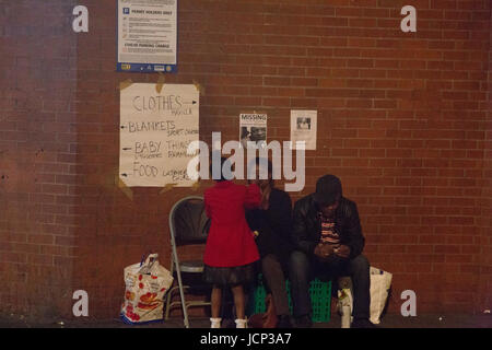 London, UK. 16. Juni 2017. Eine Familie sitzen auf Stühlen während Vigil Menschen fordern Gerechtigkeit für die betroffenen durch das Feuer, das Grenfell Tower, einem Turm Wohngebäude in West London ausgenommen. Bildnachweis: Thabo Jaiyesimi/Alamy Live-Nachrichten Stockfoto