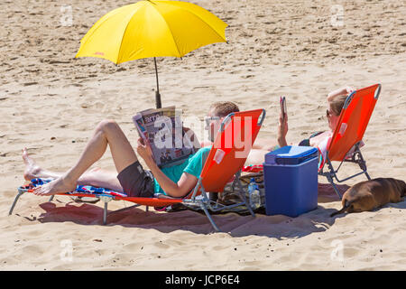 Bournemouth, Dorset, UK. 17. Juni 2017. UK-Wetter: heißer Sonnentag mit ununterbrochenen Sonnenschein. Besucher gehen ans Meer an den Stränden von Bournemouth, genießen die Sonne, die Anreise früh, um einen Platz zu bekommen, geht es nicht mehr los. Lesen Sie die Zeitung the Sun. Bildnachweis: Carolyn Jenkins/Alamy Live-Nachrichten Stockfoto