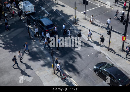 Fußgänger beim Überqueren der Straße in der Londoner City im morgendlichen Berufsverkehr Stockfoto